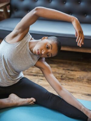 Active black woman doing revolved head to knee asana