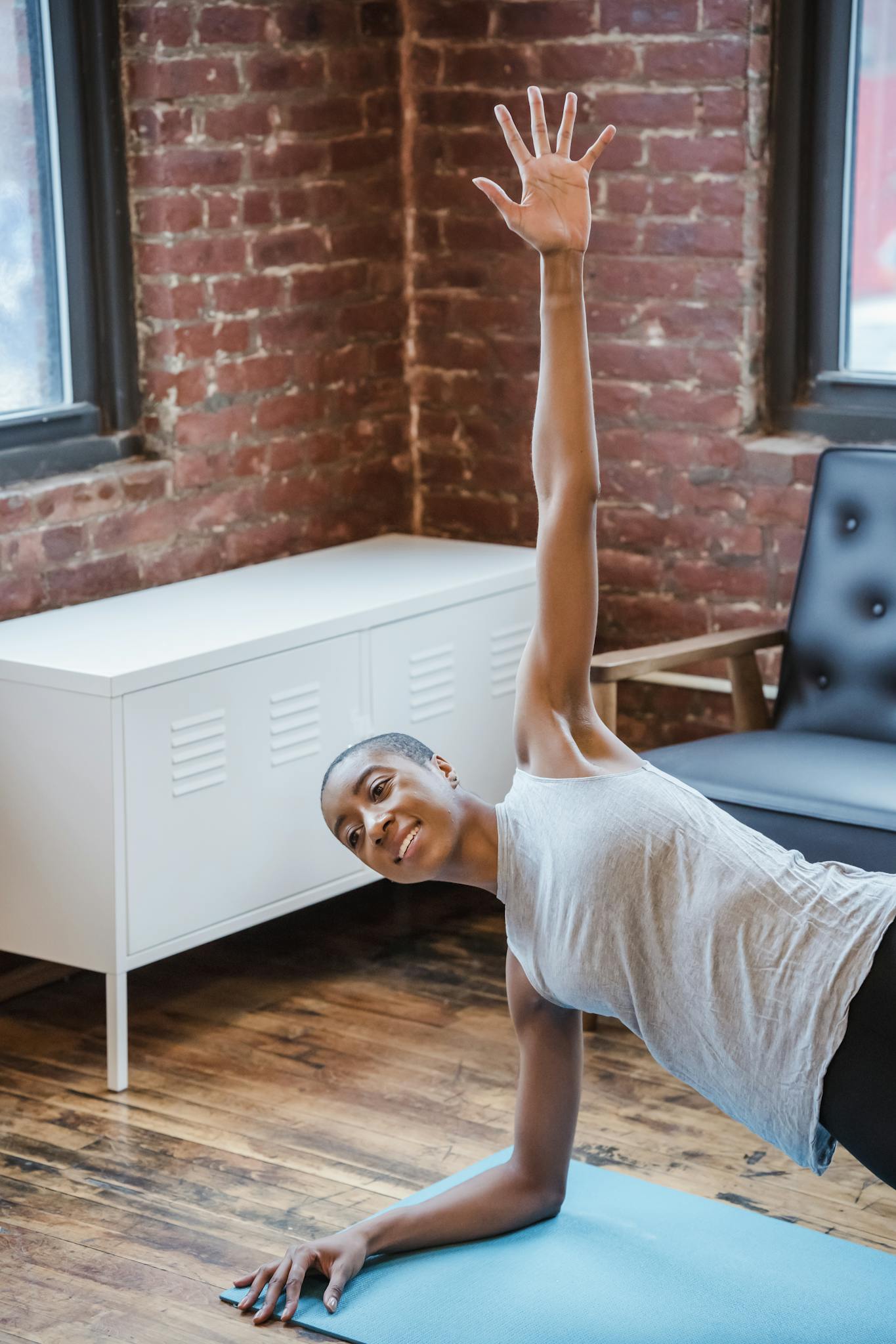 Cheerful black woman doing side plank